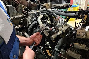 Mechaniker schraubt an einem Motor.