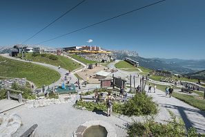 Blick auf den Spielplatz und das Restaurant in Ellmi's Zauberwelt an einem sonnigen Tag.