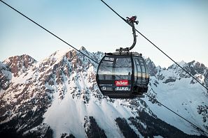Schwarze Gondel Hartkaiserbahn in Ellmau mit dem verschneiten Wilden Kaiser im Hintergrund