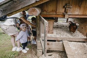 Kinder sehen sich Hühner im Garten an im Hexenwasser in Söll