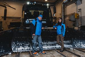 Mechaniker Mann und Frau vor Pistenbully bei den Bergbahnen SkiWelt Söll