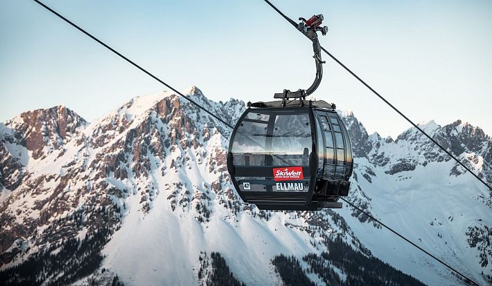 Schwarze Gondel Hartkaiserbahn in Ellmau mit dem verschneiten Wilden Kaiser im Hintergrund