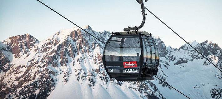 Schwarze Gondel Hartkaiserbahn in Ellmau mit dem verschneiten Wilden Kaiser im Hintergrund