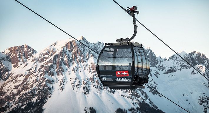 Schwarze Gondel Hartkaiserbahn in Ellmau mit dem verschneiten Wilden Kaiser im Hintergrund