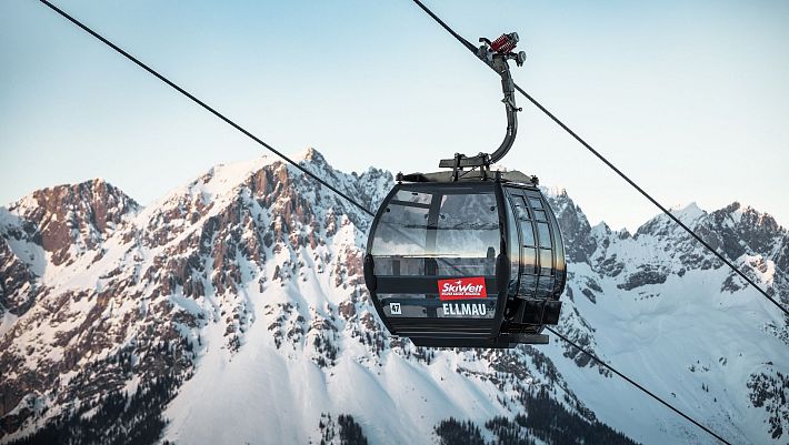 Schwarze Gondel Hartkaiserbahn in Ellmau mit dem verschneiten Wilden Kaiser im Hintergrund