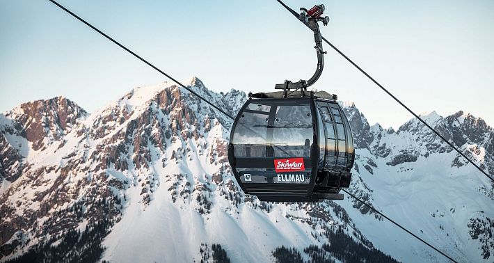 Schwarze Gondel Hartkaiserbahn in Ellmau mit dem verschneiten Wilden Kaiser im Hintergrund