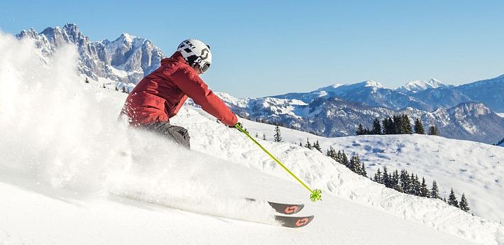 Skifahrer flitzt die Piste hinab in der SkiWelt Wilder Kaiser-Brixental.