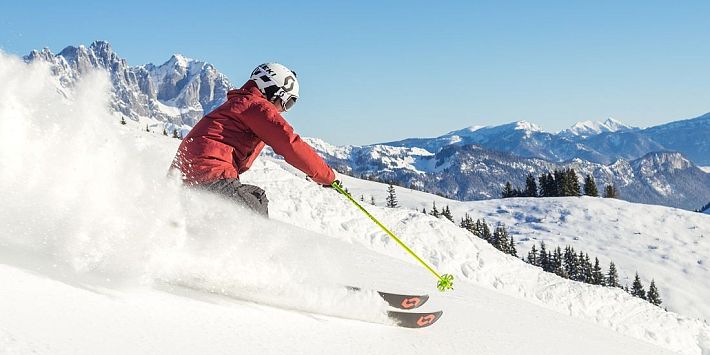 Skifahrer flitzt die Piste hinab in der SkiWelt Wilder Kaiser-Brixental.