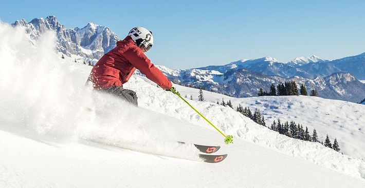 Skifahrer flitzt die Piste hinab in der SkiWelt Wilder Kaiser-Brixental.