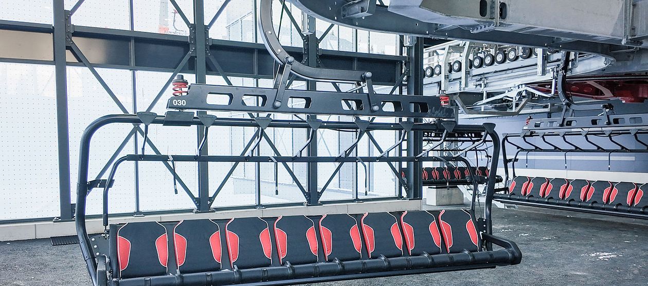Ein leerer Skilift mit roten Sitzen, der bereit für den Einsatz in einer modernen Bergstation ist.