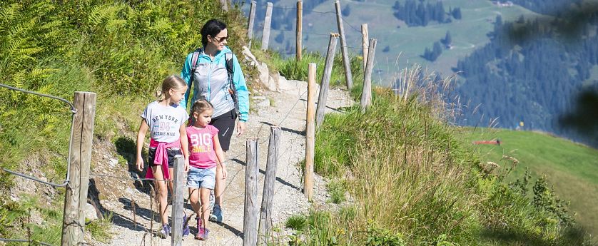 Mutter mit zwei Kindern beim wandern in der Natur.
