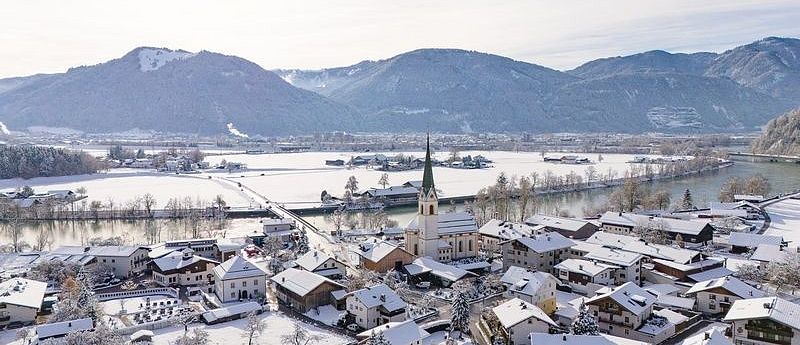 Dorf im Winter mit beschneiten Häusern.