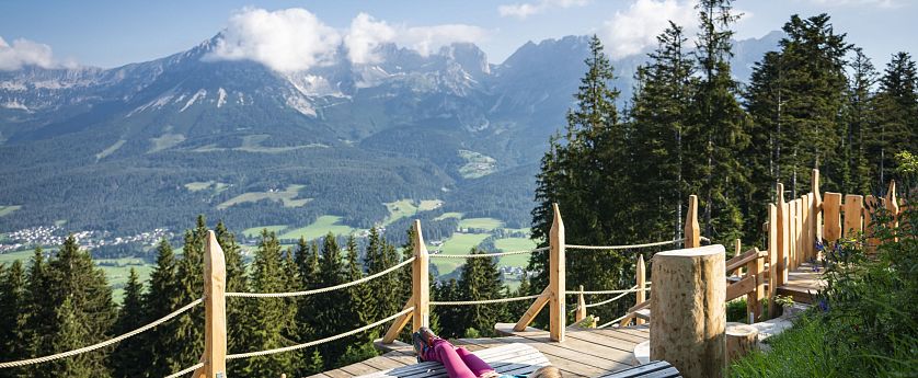 Holzliegen zum entspannen mit Ausblick auf die Berge.