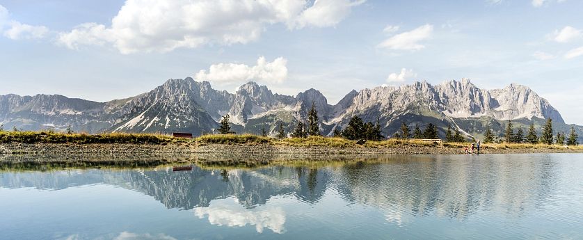 Alpenpanorama mit Bergsee im Vordergrund.