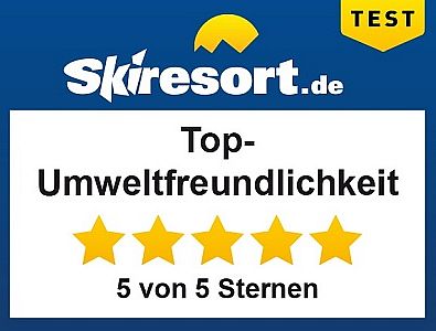 Ein Schild mit der Aufschrift "Top-Umweltfreundlichkeit" und fünf goldenen Sternen. Es ist Teil eines Tests von Skiresort.de.