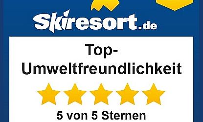 Ein Schild mit der Aufschrift "Top-Umweltfreundlichkeit" und fünf goldenen Sternen. Es ist Teil eines Tests von Skiresort.de.