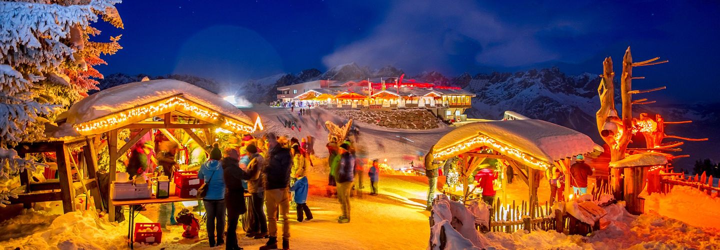 Ellmis Bergadvent Weihnachtsmarkt mit stimmungsvoller Beleuchtung bei Nacht.