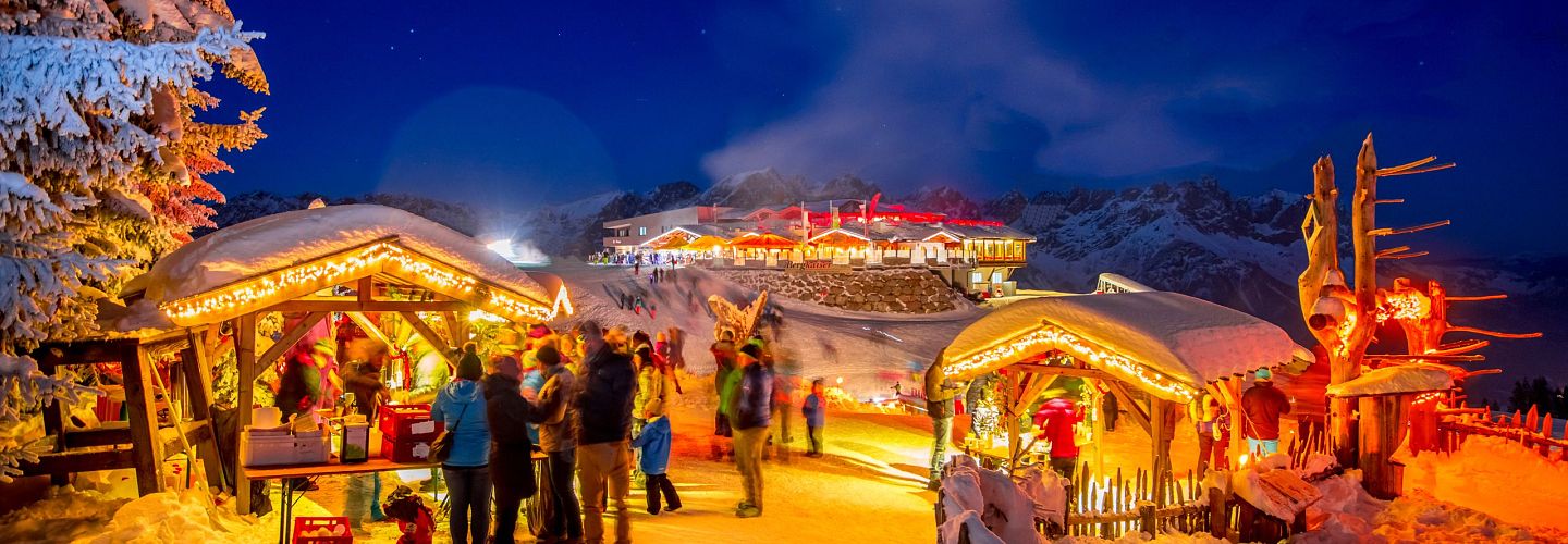 Ellmis Bergadvent Weihnachtsmarkt mit stimmungsvoller Beleuchtung bei Nacht.