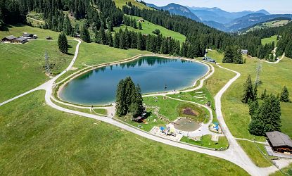 Filzalmsee und Seminarhütte in der RiesenWelt, umgeben von grünen Almwiesen, Bergen und Wanderwegen im Sommer