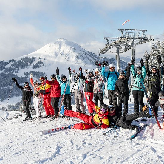 gruppen-skifahren-in-skiwelt-wilder-kaiser-gruppenfoto-bei-filzobdenbahn-mit-hohe-salve-gipfel-im-hintergrund-10