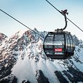 Schwarze Gondel Hartkaiserbahn in Ellmau mit dem verschneiten Wilden Kaiser im Hintergrund