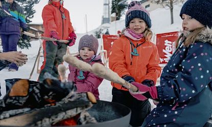 Kinder machen Stockbrot im Winter.