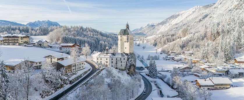 Ortschaft Mariastein im Inntal verschneit im Winnter mit Sonneneinstrahlungen