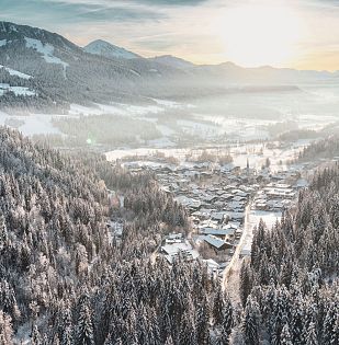 Ort Scheffau am Wilden Kaiser im Winter_Blick ins Tal mit Sonne