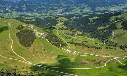 Panoramablick im Sommer über die SkiWelt Wilder Kaiser Brixental mit grünen Almwiesen, Wanderwegen, Bergseen und beeindruckender Aussicht auf die Kitzbüheler Alpen und das Kaisergebirge.