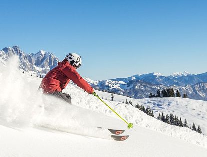 Skifahrer flitzt die Piste hinab in der SkiWelt Wilder Kaiser-Brixental.
