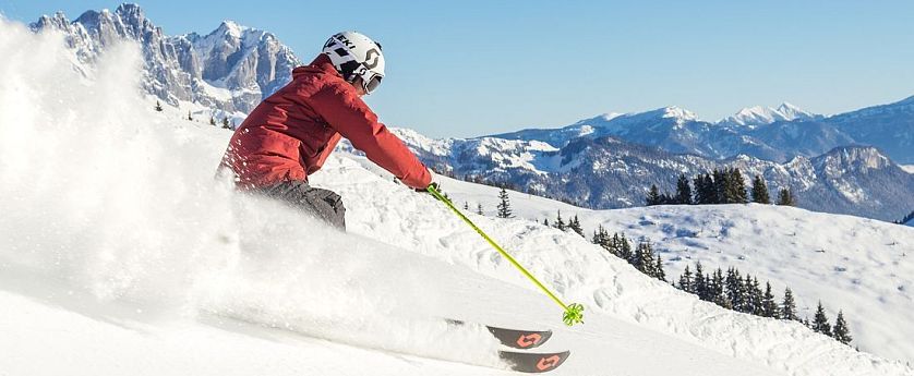 Skifahrer flitzt die Piste hinab in der SkiWelt Wilder Kaiser-Brixental.