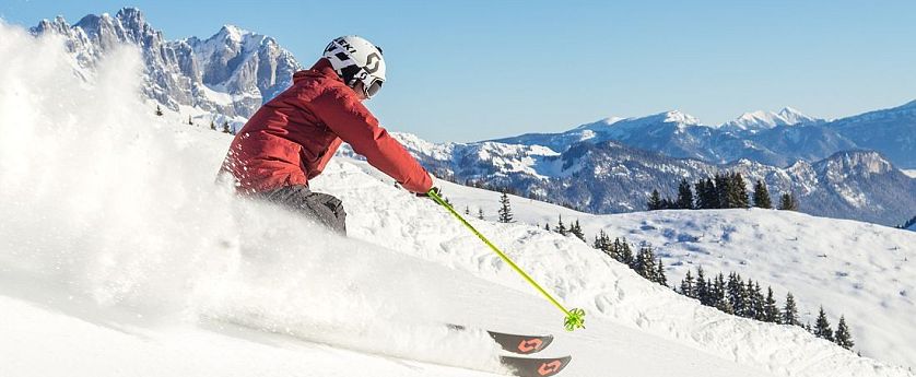 Skifahrer flitzt die Piste hinab in der SkiWelt Wilder Kaiser-Brixental.