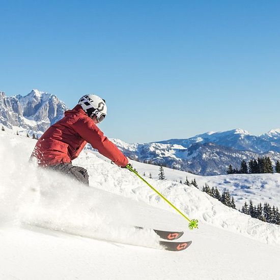 Skifahrer flitzt die Piste hinab in der SkiWelt Wilder Kaiser-Brixental.