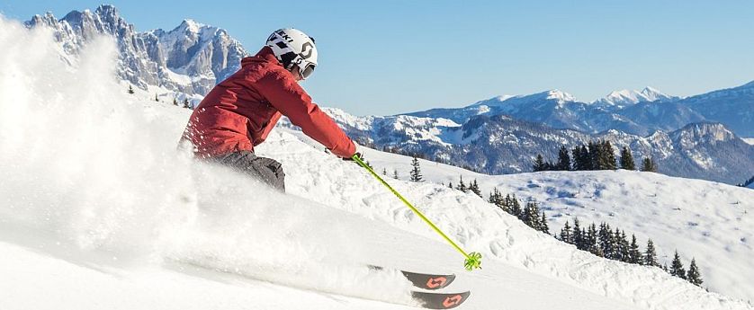 Skifahrer flitzt die Piste hinab in der SkiWelt Wilder Kaiser-Brixental.