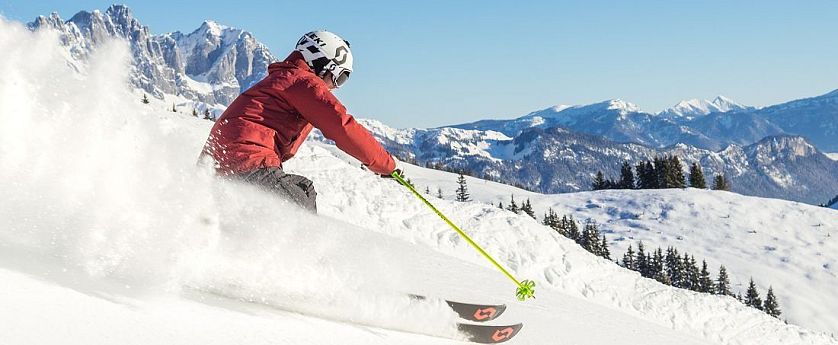 Skifahrer flitzt die Piste hinab in der SkiWelt Wilder Kaiser-Brixental.