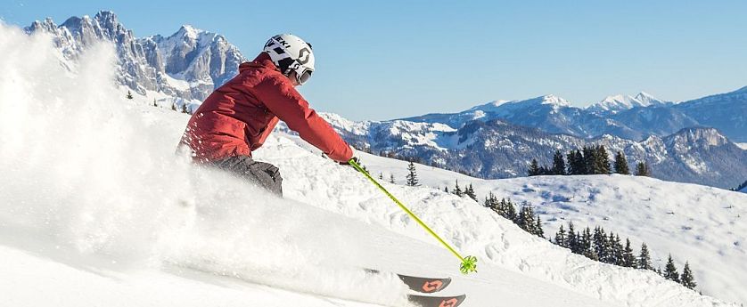Skifahrer flitzt die Piste hinab in der SkiWelt Wilder Kaiser-Brixental.