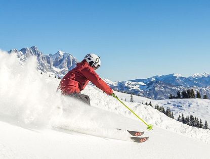 Skifahrer flitzt die Piste hinab in der SkiWelt Wilder Kaiser-Brixental.