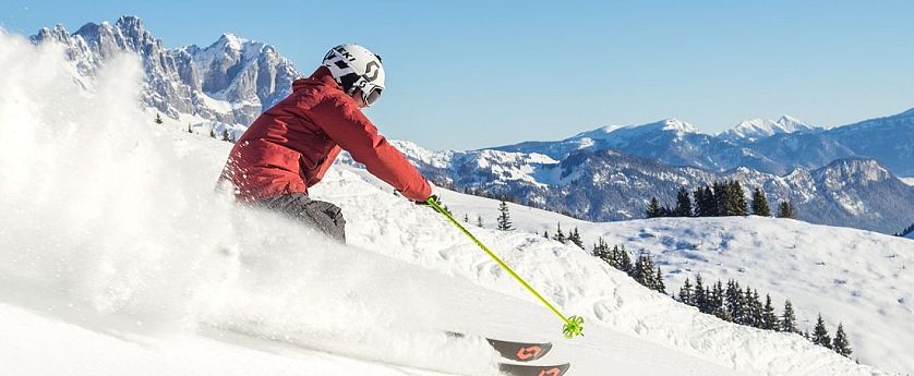 Skifahrer flitzt die Piste hinab in der SkiWelt Wilder Kaiser-Brixental.