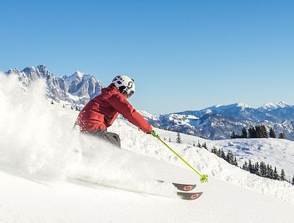 Skifahrer flitzt die Piste hinab in der SkiWelt Wilder Kaiser-Brixental.