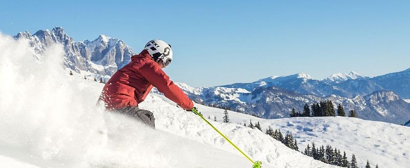 Skifahrer flitzt die Piste hinab in der SkiWelt Wilder Kaiser-Brixental.