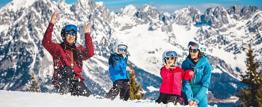 Familie spielt im Schnee.