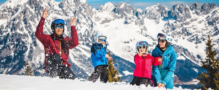Familie spielt im Schnee.