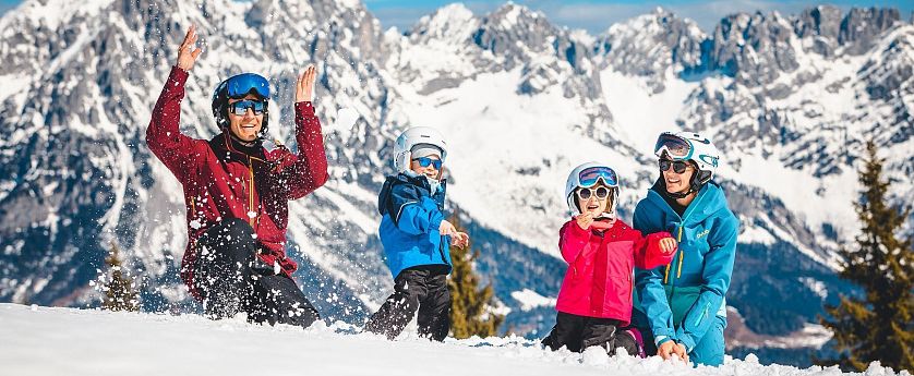 Familie spielt im Schnee.