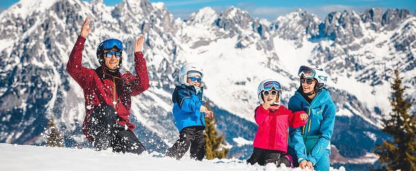 Familie spielt im Schnee.