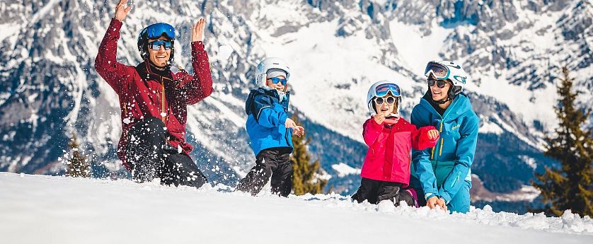 Familie spielt im Schnee.