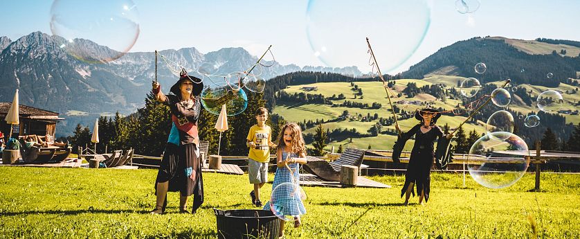 Hexen und Kinder stellen Riesenseifenblasen her.