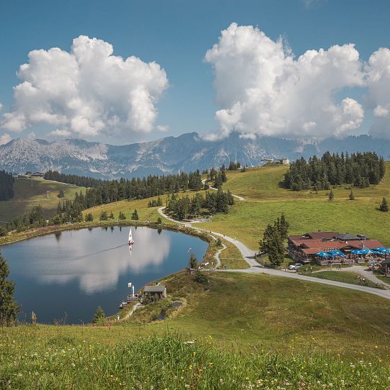 Blick auf den Bergsee und ein Restaurant in der RiesenWelt in Brixen.