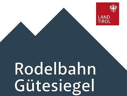 Německý nápis 'Modelbahn Gütesiegel' bílým písmem na tmavě modrém pozadí.