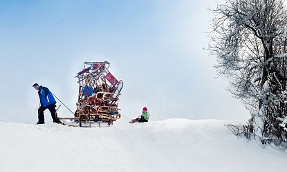 Mann tranzportiert viele Rodeln.