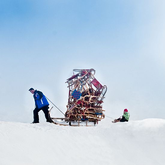 Mann tranzportiert viele Rodeln.